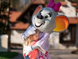 Un enfant serre dans ses bras la mascotte d’Europa-Park, Edda Euromausi.