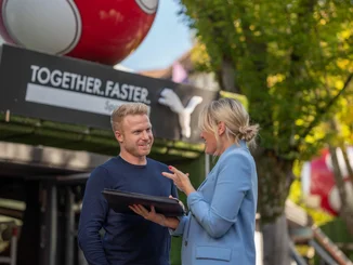 Two employees of the Europa-Park Resort in front of the PUMA store at Europa-Park.