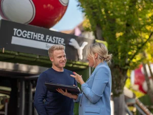 Two employees of the Europa-Park Resort in front of the PUMA store at Europa-Park.