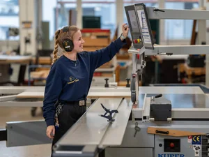 Employee of the carpentry workshop at the Europa-Park Resort at work on a cutting machine.