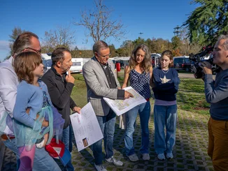 Projektpräsentation Roland Mack präsentiert einer Familie Pläne des "Europa-Park Kinderhaus Kleine Helden" gemeinsam mit DJ BoBo.
