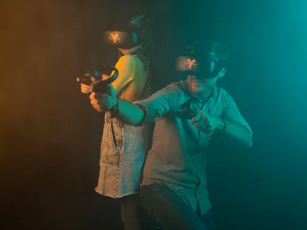 Two YULLBE players equipped with VR headsets and hand trackers.