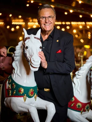 Roland Mack stands next to a wooden horse from the historic Eden Palladium carousel.