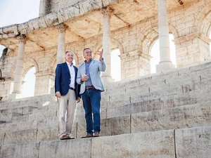 The brothers Roland and Jürgen Mack stand on the Colosseum arch in the courtyard of the themed 4* superior hotel ‘Colosseo’.