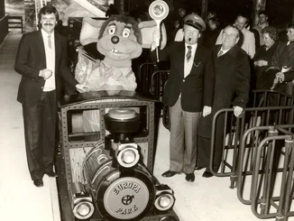 Opening of Alpine Express with the train in the centre, Roland Mack on the left, Franz Mack on the right and guests in the station building.