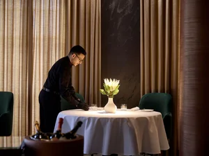 A member of staff at the two-star Michelin restaurant Ammolite – House of Light at the Europa-Park Resort is setting one of the fine dining tables.