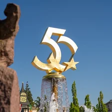 Goldene 50 auf dem Brunnen am Europa-Park Haupteingang bei blauem Himmel.
