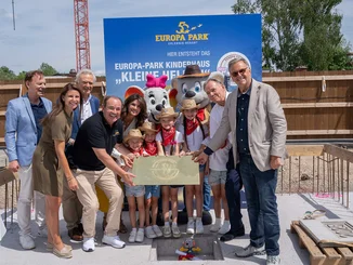 Grundsteinlegung Horst Koppelstätter, Ann-Kathrin Mack, Jürgen Mack, Wolfram Krons, Miriam Mack, Charles R. Botta und Roland Mack gemeinsam mit Kindern und Ed und Edda bei der Grundsteinlegung für das Kinderhaus.