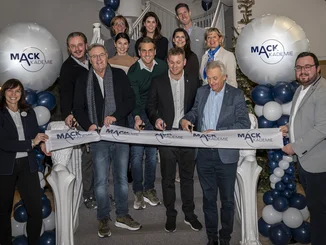 The Mack family stands on the steps of the MACK Academy and cuts a ribbon to mark the opening.