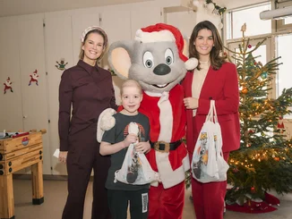 Miriam Mack and Ed Euromaus (dressed as Father Christmas) visit patients at a children's cancer clinic.