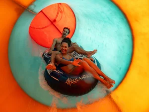 A couple slides down the fast-paced Två Fall slide together at Rulantica water world.