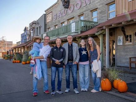 Roland Mack, project sponsor DJ BoBo and a family affected by the illness stand in front of Silver Lake City, where the 'Little Heroes Children's House' is to be built.