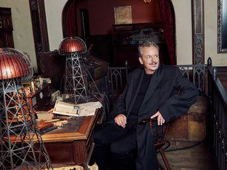 Michael Mack at Nikola Tesla's desk, on which there are two Wardenclyffe Towers.