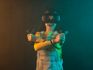 A child equipped with the VR headset and hand trackers from YULLBE.