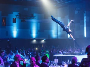A man performs impressive acrobatic figures on a pole.