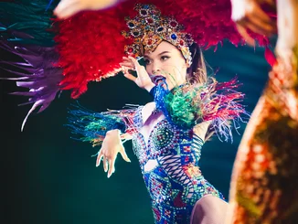 A dancer from the Europa-Park Dinner-Show wearing an extravagant headdress and colourful clothing.