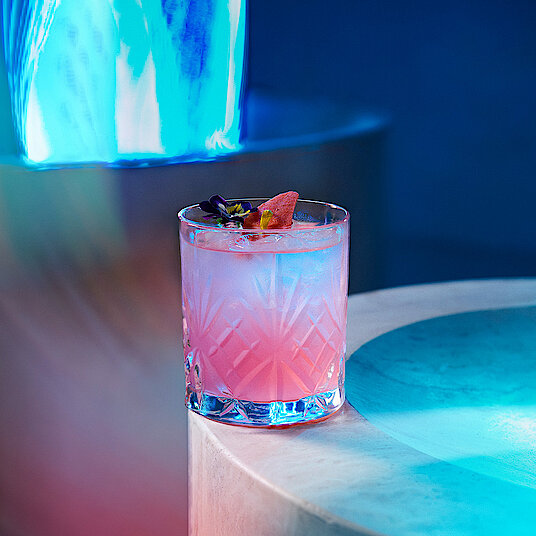 Cocktail Waterfall Eatrenalin Kleines Whiskeyglas mit einem rosa-weißen Cocktail im Raum "Waterfall" bei Eatrenalin Late Night.