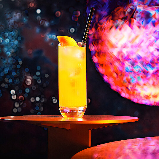 Cocktail Ocean Eatrenalin Langes Longdrinkglas mit einem fruchtig-orangenem Cocktail gefüllt – im Raum "Ocean" bei Eatrenalin Late Night.