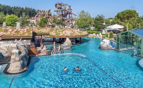 Gäste plantschen ausgelassen im großen Outdoor-Pool Svømmepøl in Rulantica.