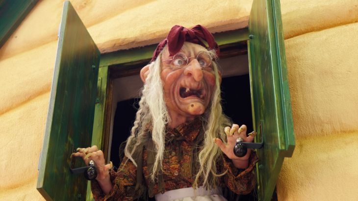 Die Hexe von Hänsel und Gretel schaut aus dem Fenster des Lebkuchenhauses in Grimms Märchenwald im Europa-Park.