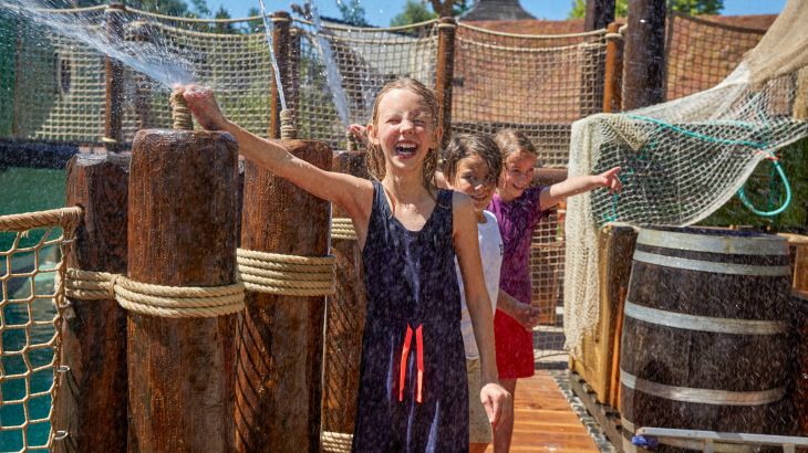 Drei Kinder spritzen mit Wasser in Paul's Playboat im Irischen Themenbereich des Europa-Park.