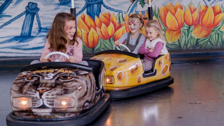 Zwei Mädchen in einem Mini-Scooter rammen den Mini-Scooter von einem anderen Mädchen im Holländischen Themenbereich des Europa-Park.