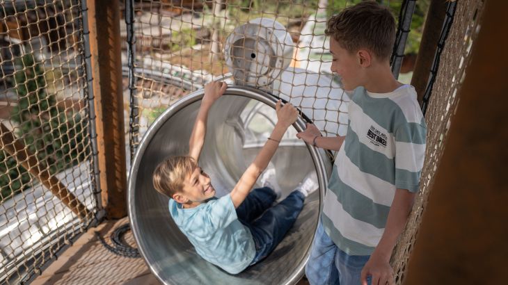 Zwei Kinder stehen gemeinsam vor dem Start einer Rutsche auf dem Yomi Abenteuer Trail im Europa-Park. 