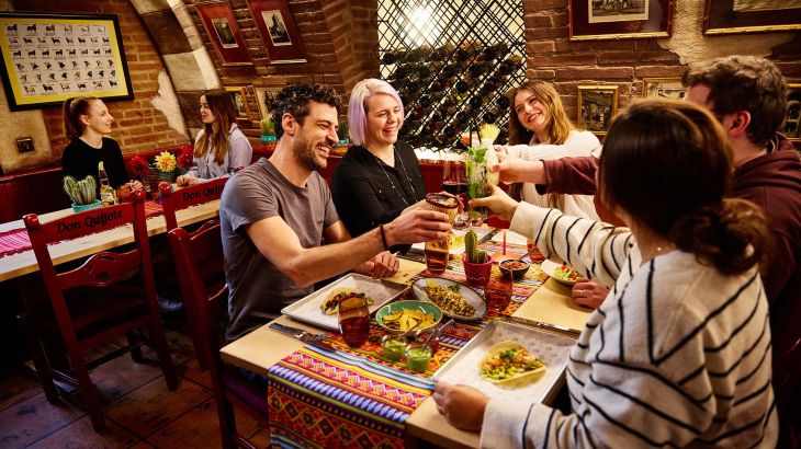 Un gruppo di amici brinda con dei cocktail mentre gusta un ottimo pasto al ristorante Don Quichotte all’Europa-Park.