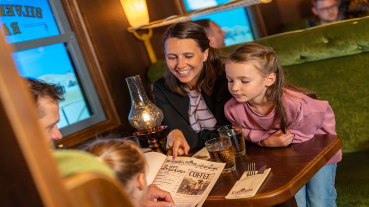 Ampia sala interna della Cantina Amigo nella Silver Lake City dell’Europa-Park Resort, con panche e tavoli in legno scuro.