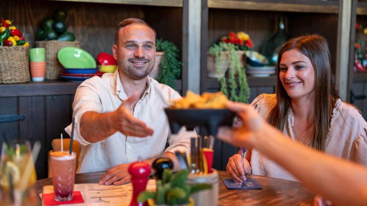 Een groep eet in de Bodega Mexican Bar & Lounge: de gerechten worden geserveerd.