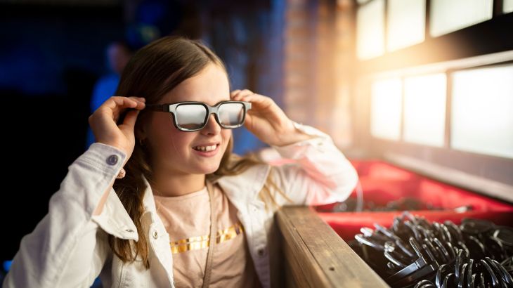 Ein Mädchen trägt eine 3D-Brille in der Attraktion GRAND PRIX EDventure im Europa-Park.