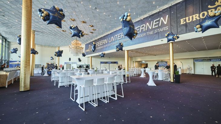 Geschmücktes Foyer mit weißen Barhockern und Tischen. Die Dekoration ist anlässlich der 50 Jahre Europa-Park.