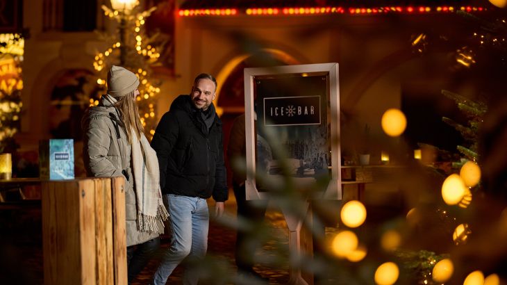 Un couple se tient devant l’entrée de l’Ice Bar dans le quartier espagnol d’Europa-Park. L’ambiance de Noël est omniprésente.