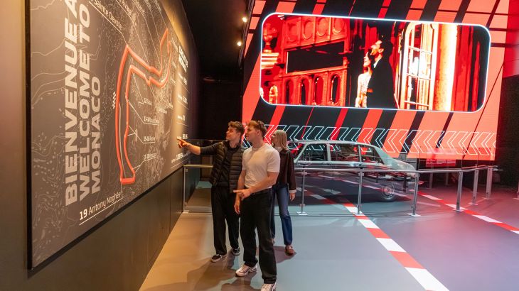 Drei Personen schauen sich die Ausstellung im Monegassischen Themenbereich des Europa-Park an.