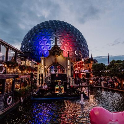 Der atmosphärisch geschmückte Französische Themenbereich während der Sommernachtsparty im Europa-Park. Die Kugel der Attraktion Eurosat – CanCan Coaster wird in den französischen Nationalfarben beleuchtet.