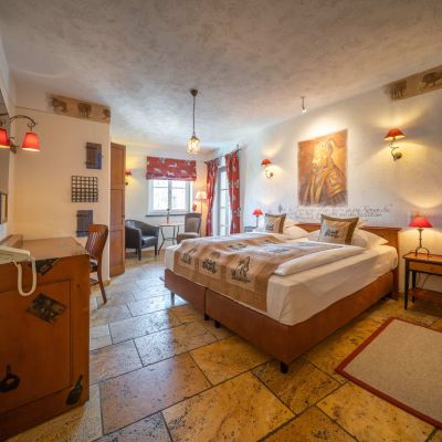 Deluxe room with double bed, television, desk, chair and window