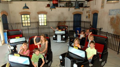 Kinder fahren in den Autos der Attraktion Crazy Taxi im Englischen Themenbereich des Europa-Park.
