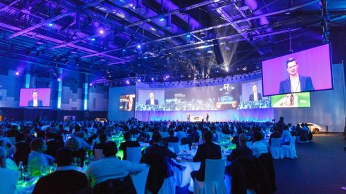 Ein Vortrag auf einer großen Bühne mit mehreren LED-Bildschirmen im Confertainment Center des Europa-Park Erlebnis-Resorts.