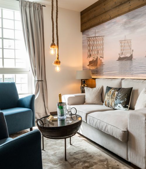 Suite a tema Blauzahn nell’hotel Krønasår con divano, poltrona e murale